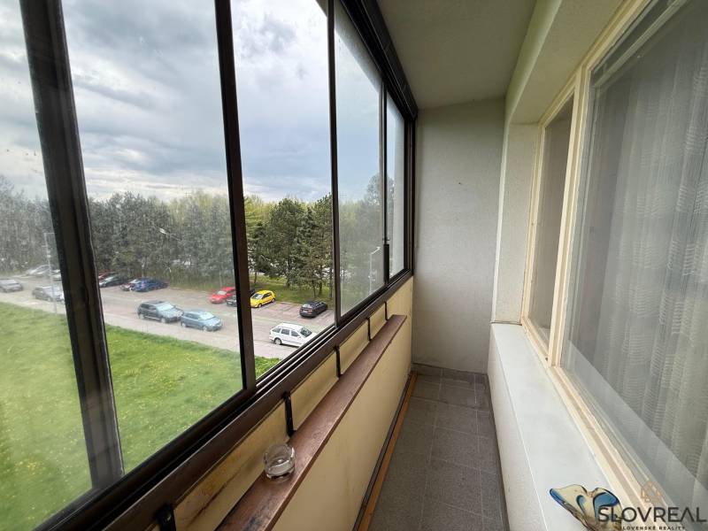 Glazed balcony with a view of the parking lot and greenery in Detva, 3-room apartment.