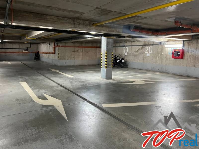 Underground garage with parking spaces, markings, and a motorcycle, Košice - Staré Mesto district.