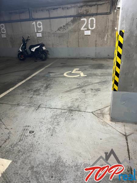 Handicapped parking space with a parked scooter in the garage.