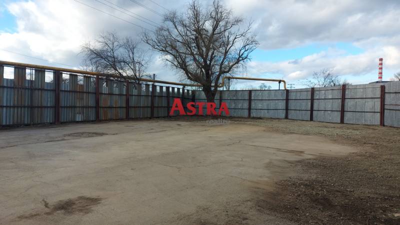 Commercial land in Košice - Juh district with fencing and trees.