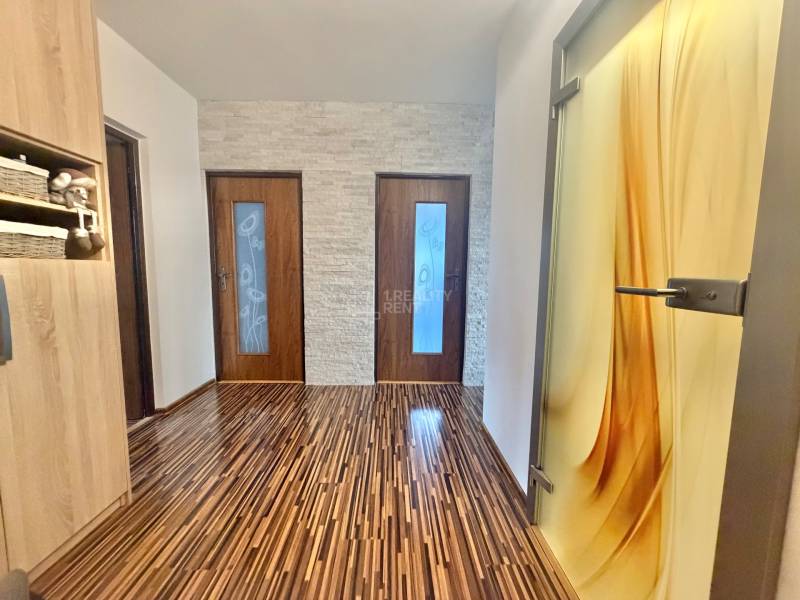 A hallway with a patterned floor featuring a wooden decor in a 4-room apartment.