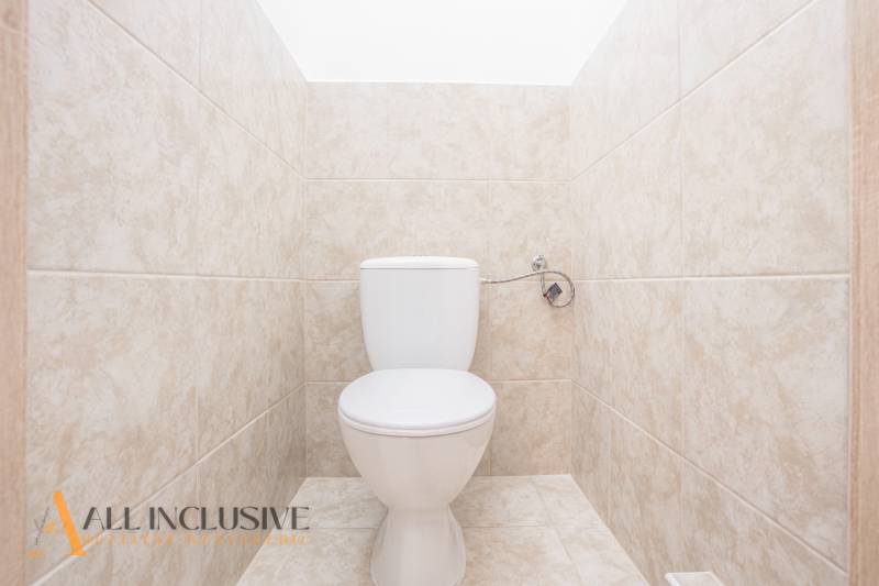 A restroom tiled with light tiles in a building.
