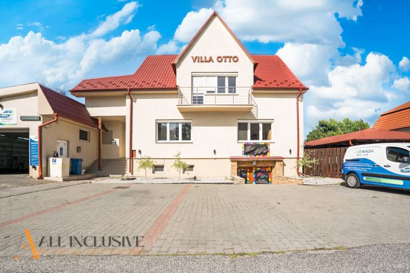 A building with a red roof and designated parking in Dunajská Streda.