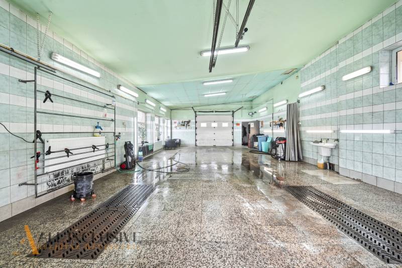 Interior wash hall with a wet floor and light tubes on the ceiling.