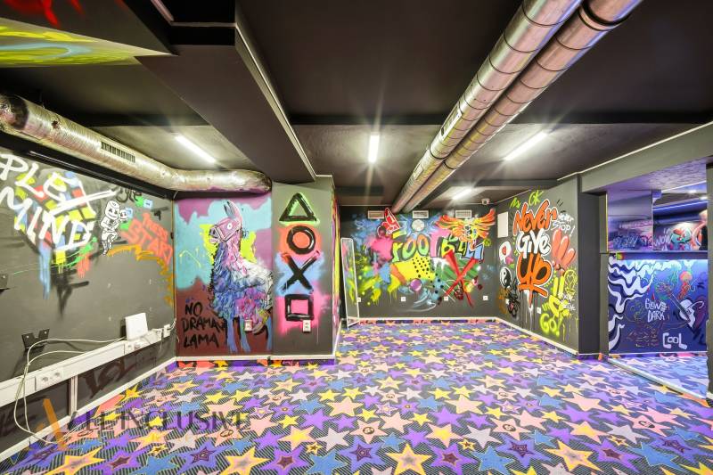 The interior of a building with colorful graffiti and a patterned carpet.