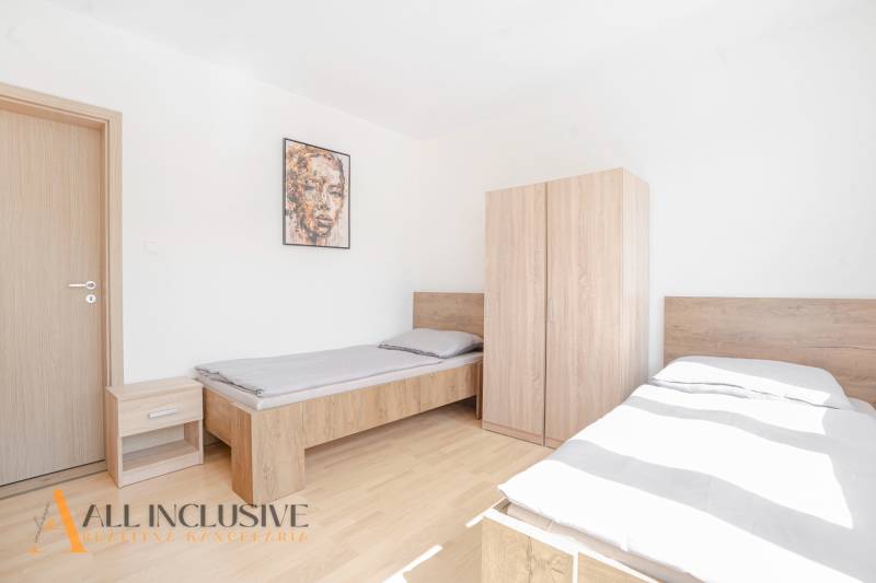 A bedroom with two beds and furniture, a floor with a wooden decor, a picture on the wall.