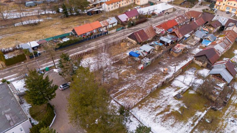 Aerial view of snow-covered gardens in Nálepkovo with multi-colored roofs and construction sites.
