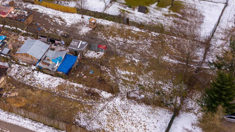Gardens in Nálepkovo with icy snow, older shelters, and fences in winter.