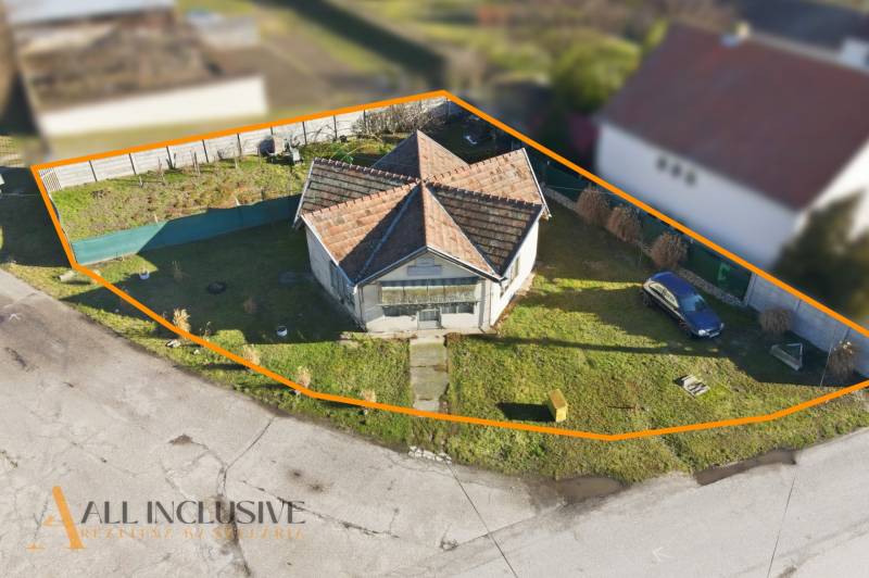 Land for sale for residential purposes in Zemianska Olča with a house and a grassed area.