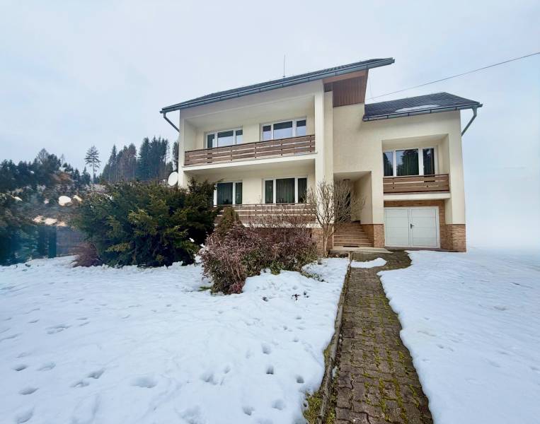 The family house in Čadečka in Čadca is surrounded by a snowy garden and low-maintenance shrubs.