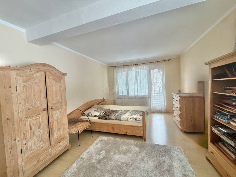 A bedroom in a family house with wooden furniture and a floor with a wooden decor.