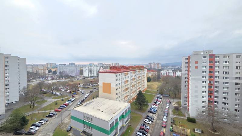 View of the housing estate in Bratislava-Petržalka on Holíčska Street with parking lots and apartment buildings.