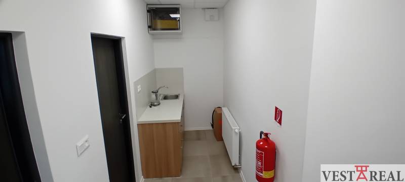 A small kitchenette in the offices with a sink, fire hydrant, and radiator.