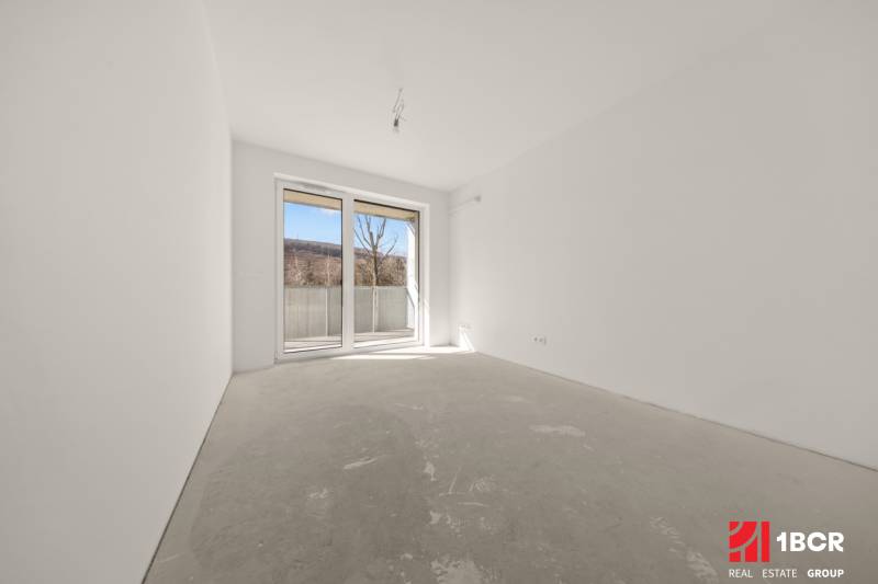 An empty room with a large window in a 4-room apartment, light walls and a window to the terrace.