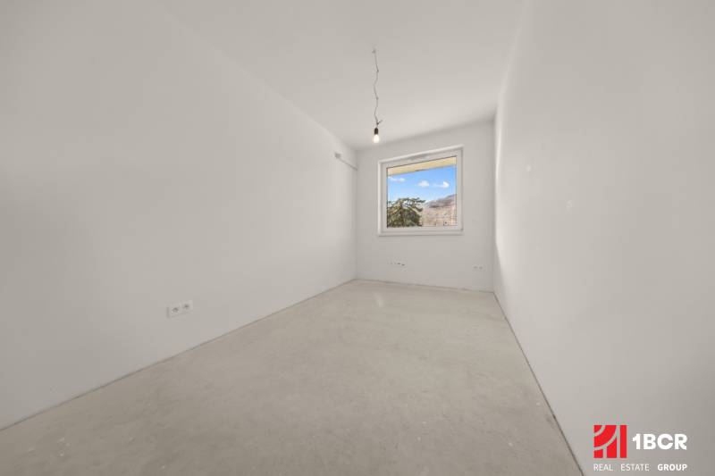 Empty room with a window, simple walls, part of a 4-room apartment.