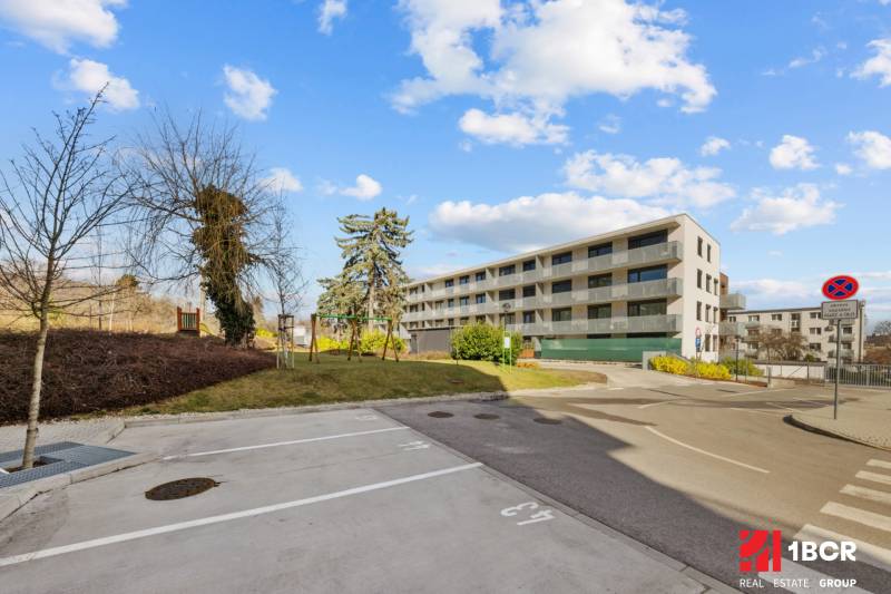 Apartment building on Skalická Road in Bratislava - Nové Mesto. In the foreground are parking spaces.