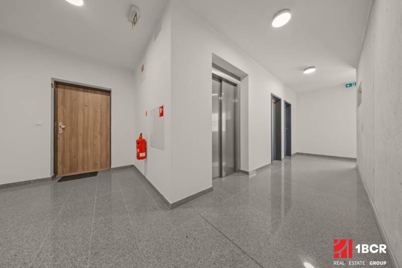 Entrance hallway with doors and an elevator in a 4-room apartment, floor with wood decor.