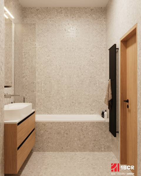 A bathroom with light tiles, a wooden cabinet under the sink, and a dark ladder radiator.