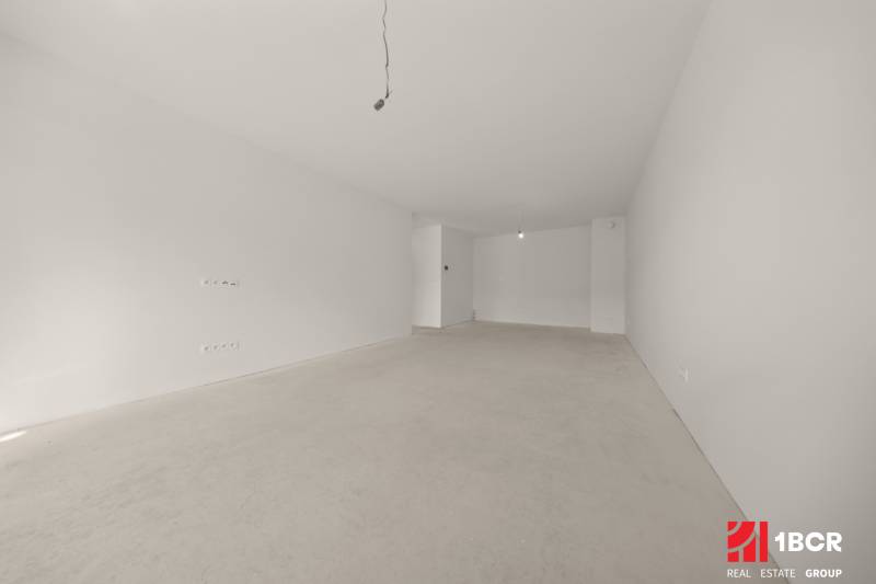 A spacious room in a 4-room apartment with white walls and an unfinished floor.