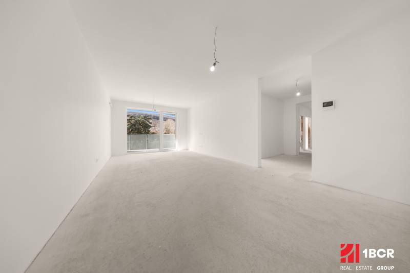A spacious room in a 4-room apartment with large windows and bare walls.