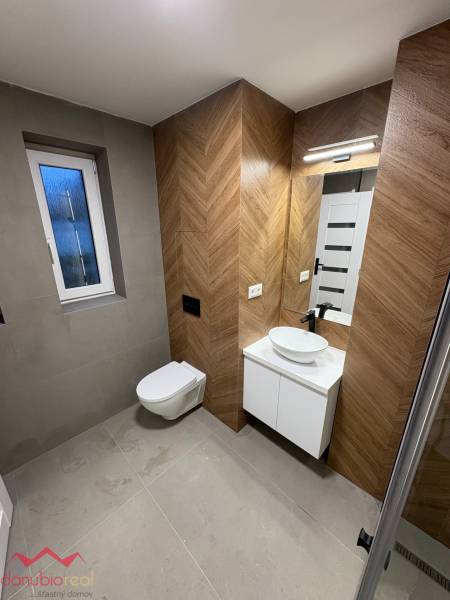 Bathroom in a 3-room apartment with tiles and a wooden decor floor.