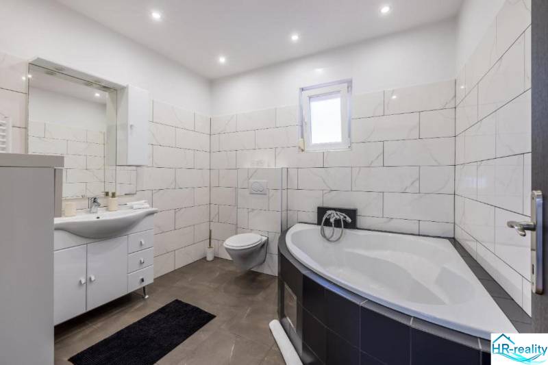 Bathroom in a villa with a bathtub, wall-hung toilet, and modern tiles.