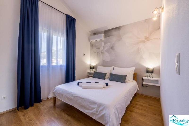 Bedroom in a villa with large flowers on the wall and a floor with a wooden decor.