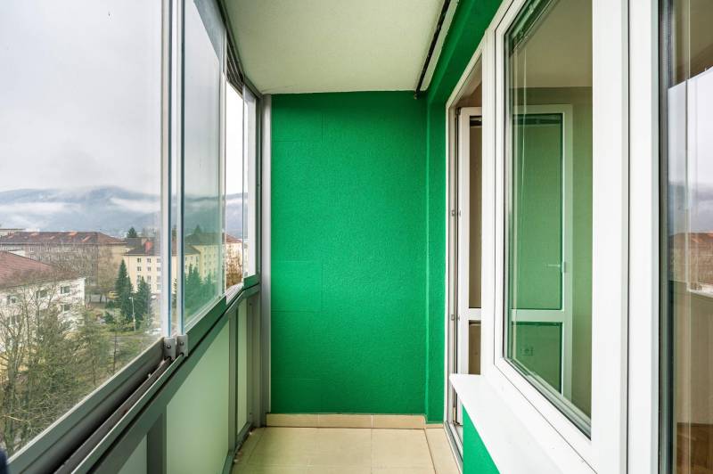 A green balcony with a view of buildings and mountains in Banská Bystrica on Trieda SNP.