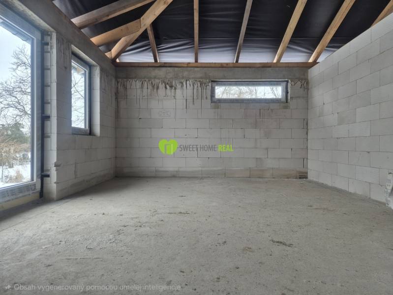Unfinished interior of a family house with a concrete floor and frameless windows.