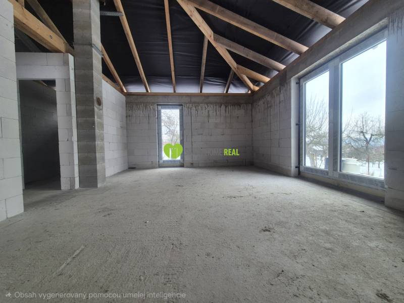Unfinished interior of a family house with a concrete floor and large windows.
