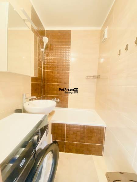 Bathroom in a 2-room apartment with a sink, bathtub, and washing machine.