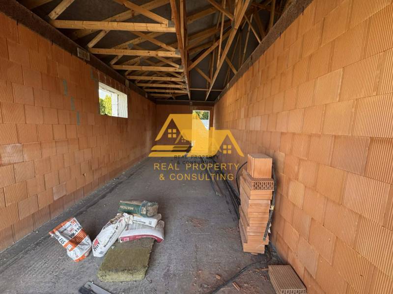 Construction of a family house on a street in Nové Zámky with brick walls and a beam ceiling.