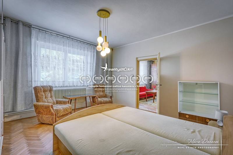 A bedroom in a family house with light wooden furniture and comfortable chairs.