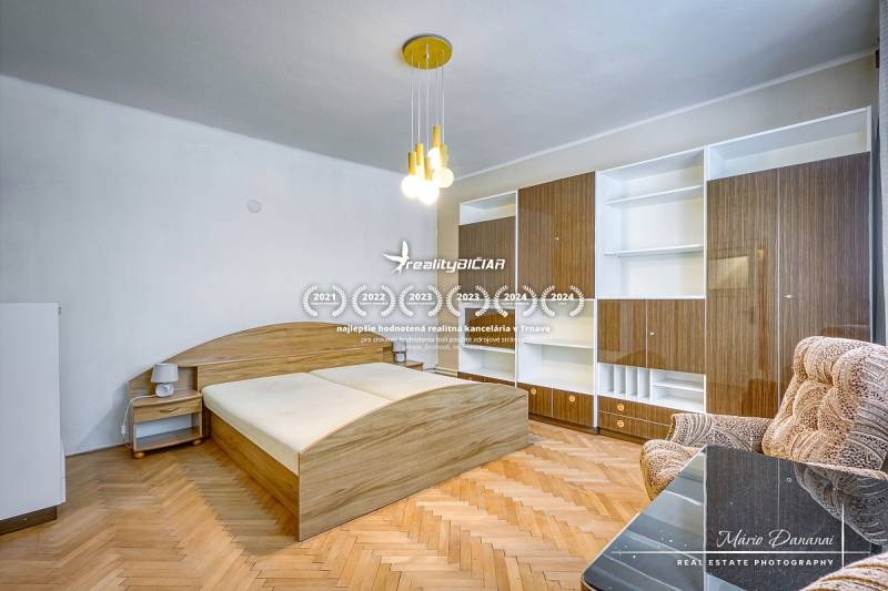 Bedroom in a family house with wooden flooring, a bed, and a built-in wardrobe.