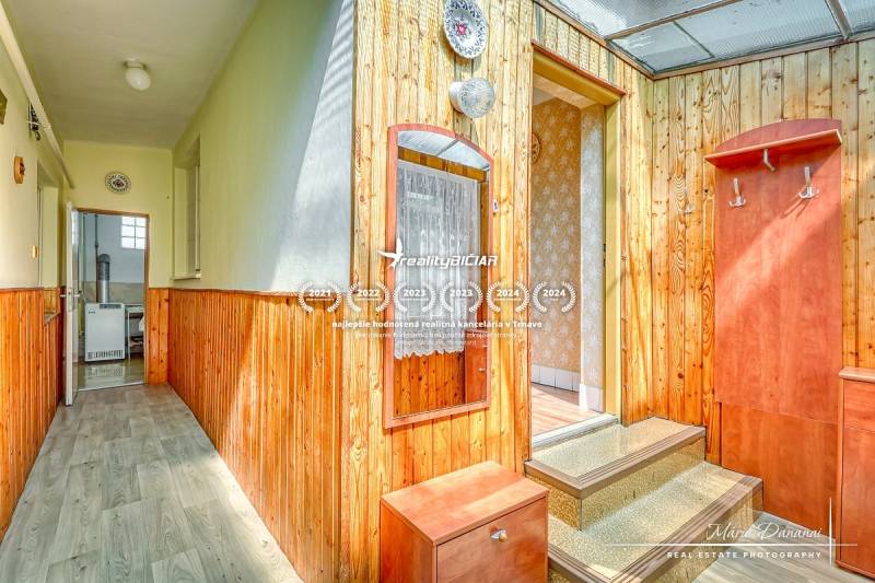 Wooden interior with a hallway and entrance in a family house with light walls.