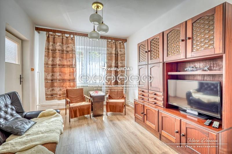 Living room with a wooden set, sofa, and television in a family house.
