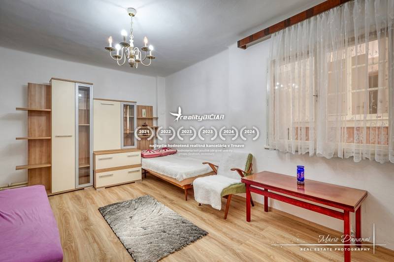 A family house with wooden flooring, chandeliers, and furniture, a room with daylight.