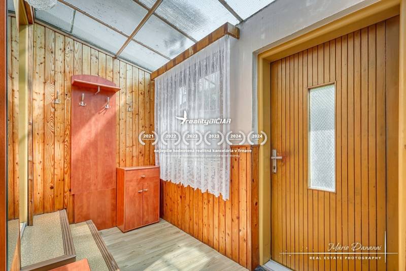 Entrance hall in a family house with wooden paneling, a shoe cabinet, and a coat rack.