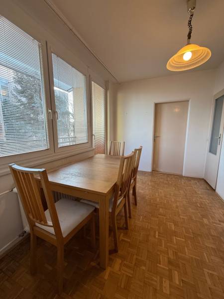 Dining room with a table and chairs in a 3-room apartment, floor with wood decor.