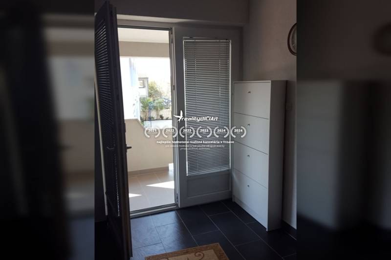 Balcony entrance in a family house with tiled floor and white furniture.