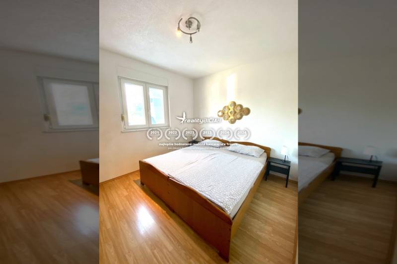 Bedroom in a family house with a double bed and a wooden decor floor.