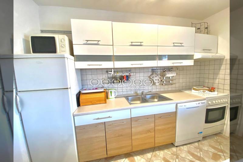 Kitchen in a family house with white cabinets, a stove, and a microwave.