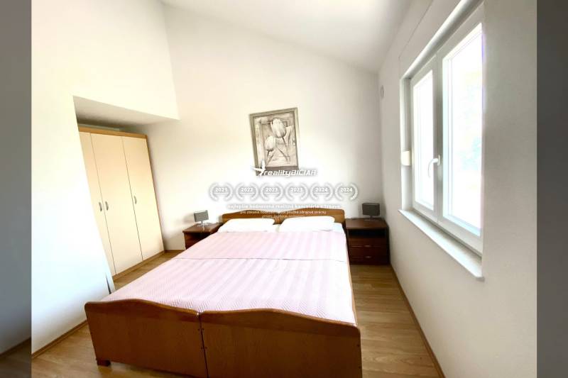 Bedroom in a family house with a double bed and a floor with a wooden decor.