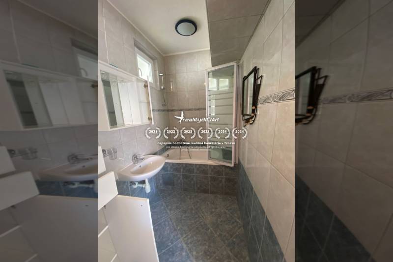 A bathroom in a family house with ceramic tiles and a shower enclosure.