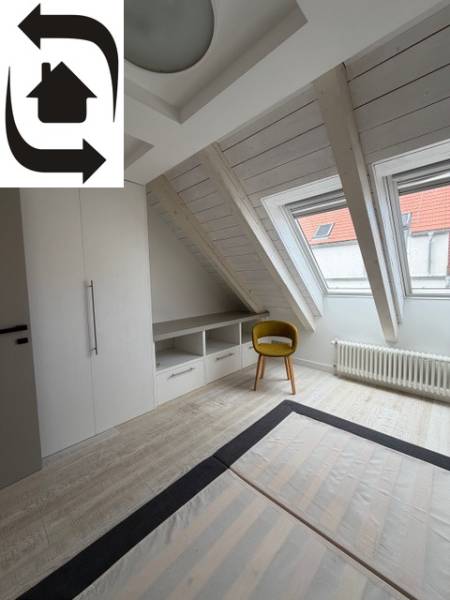 Attic room with wood-decor flooring, built-in wardrobe, and yellow chair.