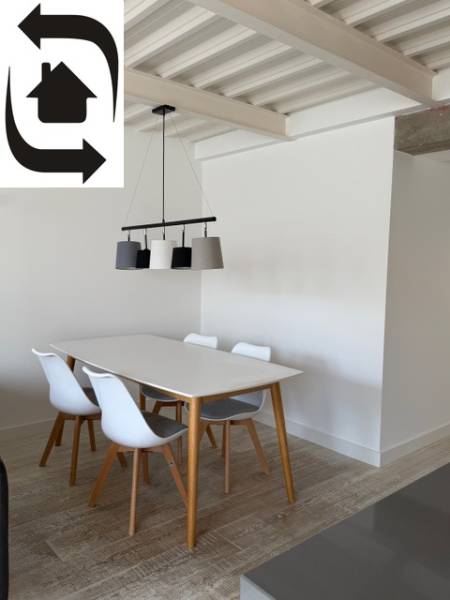 Dining table with chairs in a 4-room apartment, white walls, floor with wooden decor.