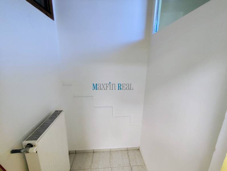 Commercial space with a radiator and white walls, floor with white tiles.