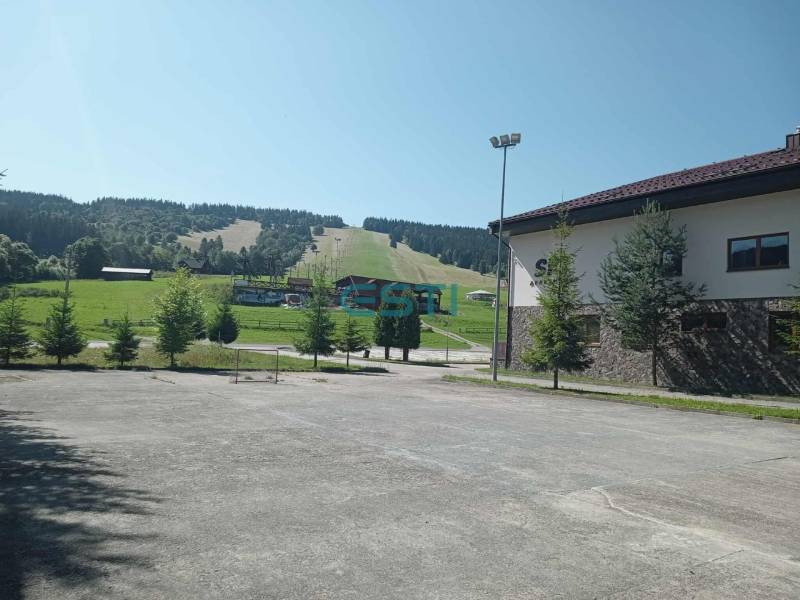 Ski slope in Makov with an adjacent building and greenery in the surroundings.