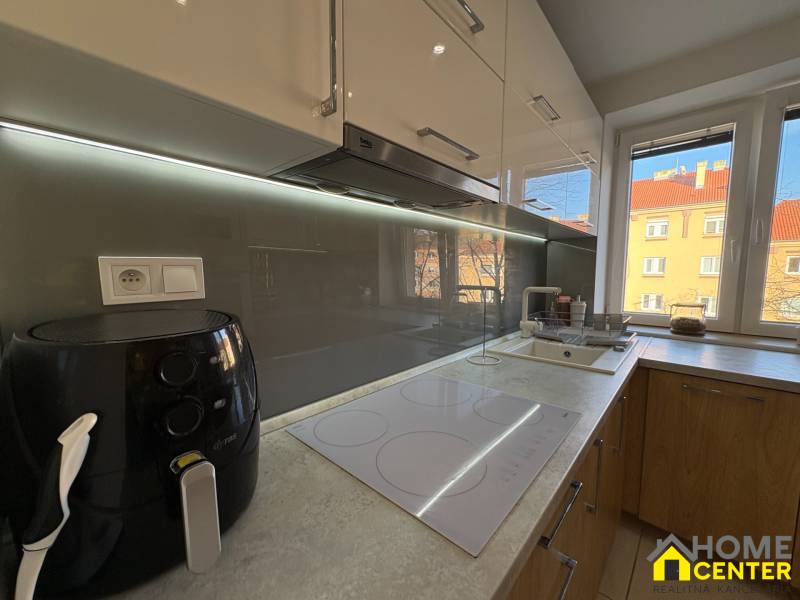 A kitchen unit with an electric stove and a window in a 2-room apartment.