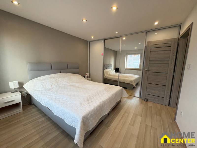 Bedroom in a 2-room apartment with a wooden decor floor.